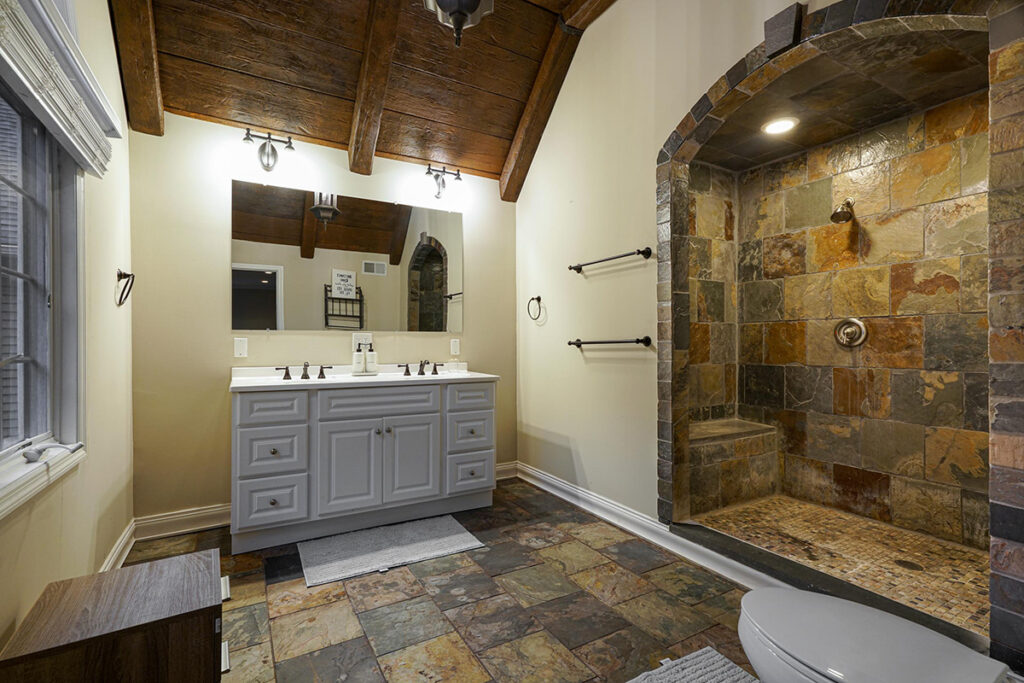 a large modern bathroom with stone floor and shower