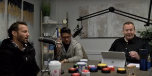 BlueCrest Health Group employees sit at a table with microphones to deliver a podcast