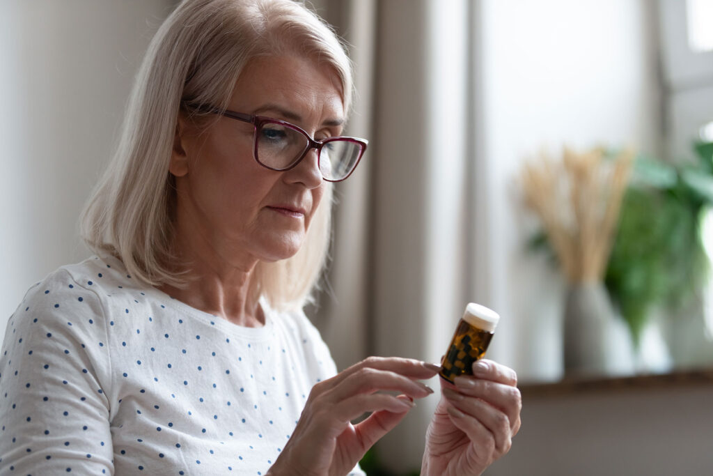 a person looks at a pill bottle closely after researching if they can be addicted to xanax