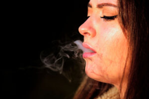 a woman smokes weed for its relaxing depressant effects