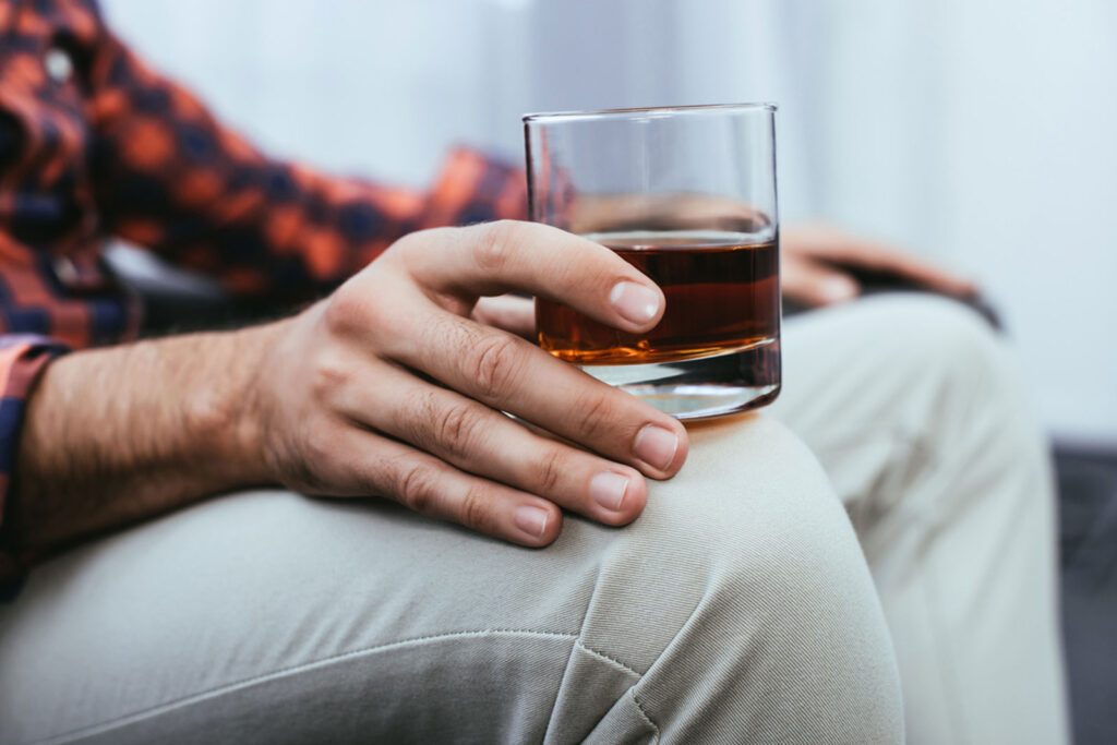 young man holding glass of whiskey