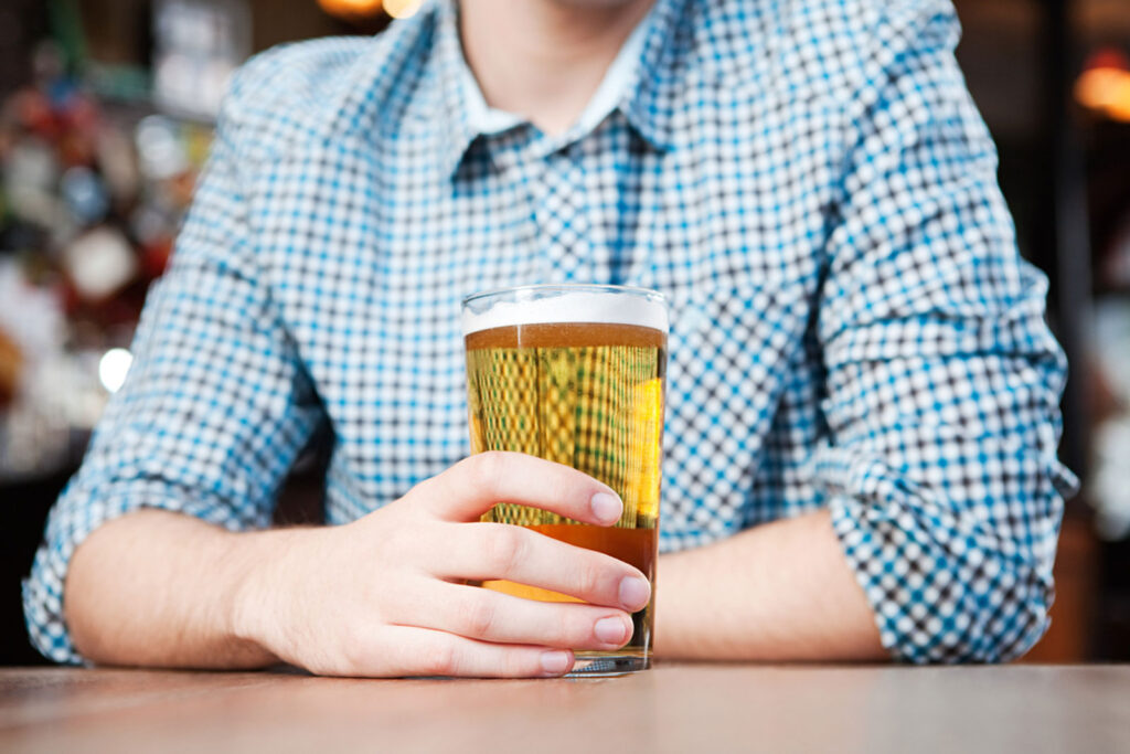 Young man in bar drinks beer